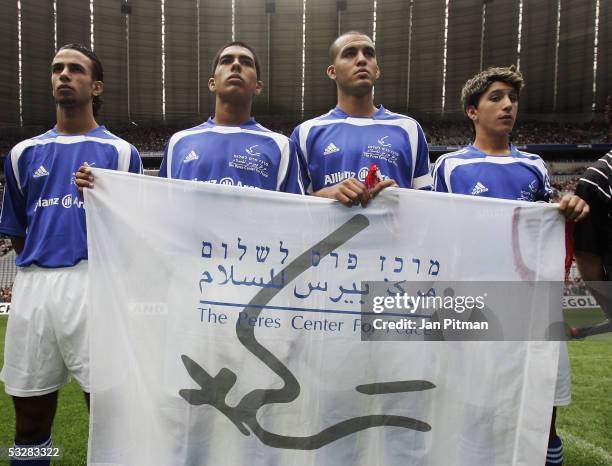 Players of the Israeli and Palestinian Peres Center "Peace Team" hold up a banner before the friendly match between the under 17 Team of Bayern...