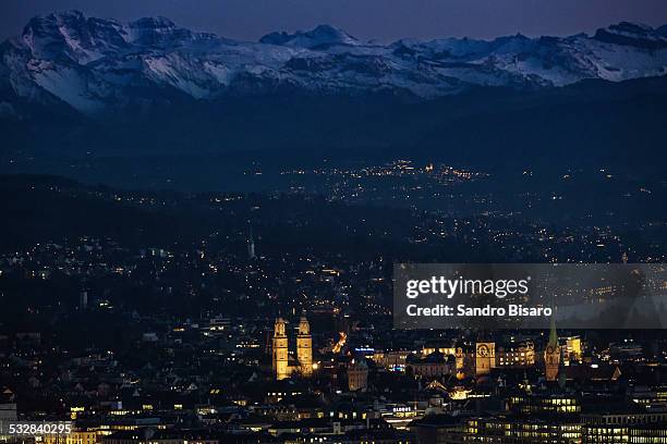 zurich old town with mountains skyline in winter - grossmünster stock-fotos und bilder