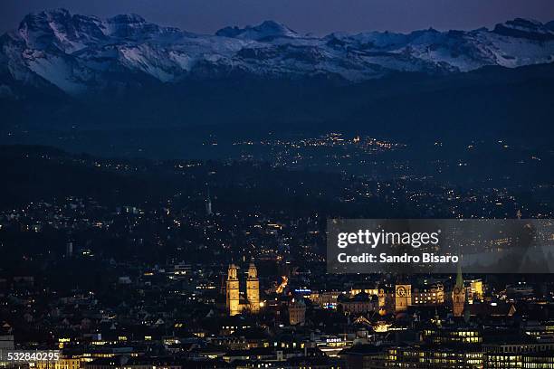 zurich old town with mountains skyline in winter - grossmunster cathedral stock pictures, royalty-free photos & images