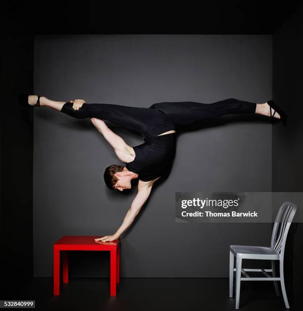 man doing hand stand and splits on table in room - male gymnast stock pictures, royalty-free photos & images