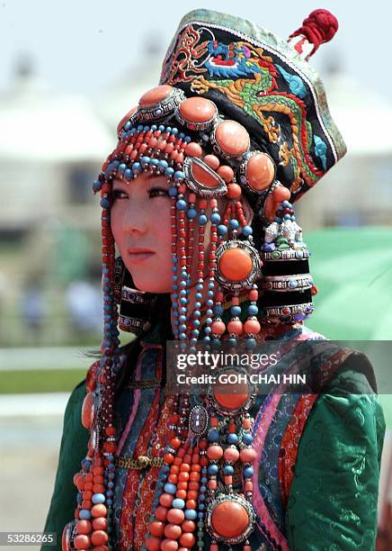 Chinese Mongolian model shows off a latest in traditional fashion, designed by a Mongolian designer, during the Naadam festival on the grassland of...