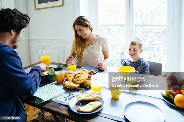 happy family having breakfast together at home - pain au chocolat stock pictures, royalty-free photos & images