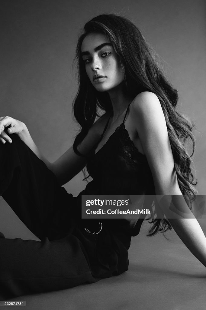 Beautiful girl sitting on the floor at the studio