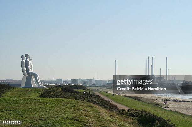 Industrial area at the harbour of Esbjerg, Denmark. Row of giant statues in the foreground. September 2011