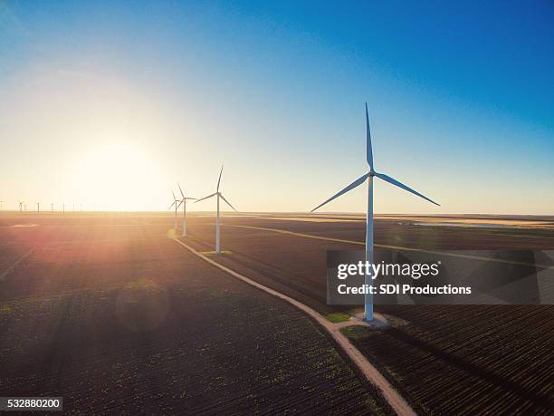 wind turbines at sunrise - ploughed field stock pictures, royalty-free photos & images