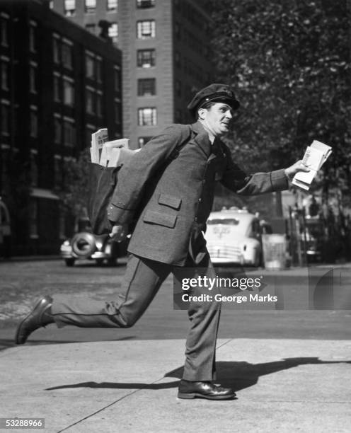 letter carrier walking down street - postbode stockfoto's en -beelden