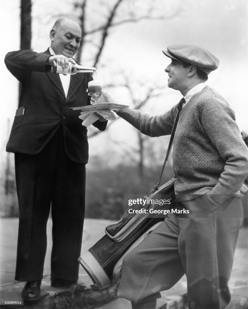 Golfer being served drink by butler