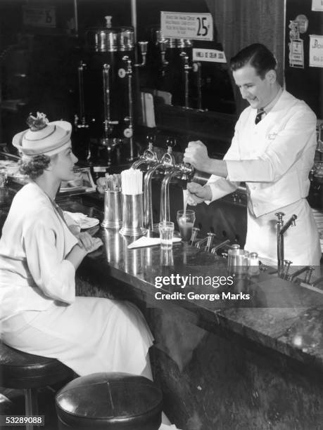 woman at counter of ice cream parlor - soda fountain stock pictures, royalty-free photos & images