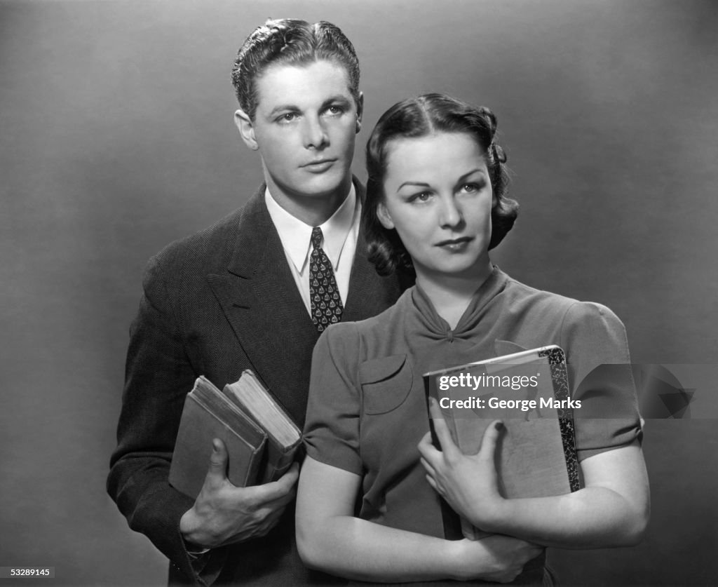 Man and woman posing with books
