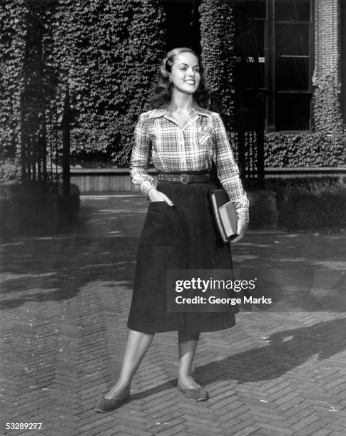 woman in dress holding books - mani in tasca 1950 foto e immagini stock