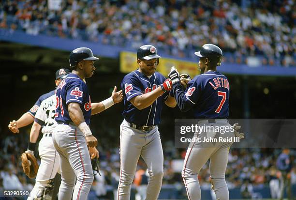 Albert Belle of the Cleveland Indians is greeted by Kenny Lofton and Julio Franco during an MLB game at Tiger Stadium in Detroit, Michigan. John...