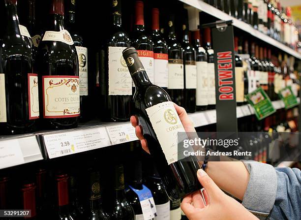 In this photo illustration, a woman looks for a bottle of redwine in a supermarket on July 26, 2005 in Luneburg, Germany. Sparked by the election...