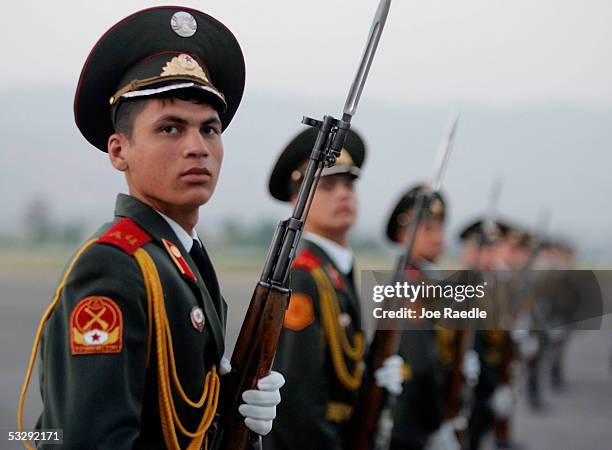 Tajikistan army soldiers stand to attention as U.S. Secretary of Defense Donald Rumsfeld prepares to walk to his waiting U.S. Air force plane on his...