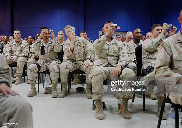 Military personnel take photographs of U.S. Secretary of Defense Donald Rumsfeld as he arrives for a town hall-style meeting July 27, 2005 at the...