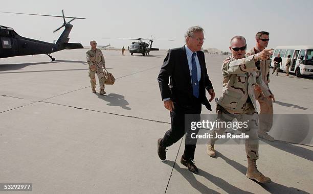 Secretary of Defense Donald Rumsfeld walks across a tarmac after arriving by helicopter to speak to U.S. Army soldiers at a town hall-style meeting...