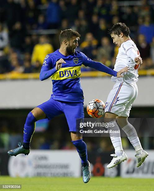 Gino Peruzzi of Boca Juniors fights for the ball with Sebastian Fernandez of Nacional during a second leg match between Boca Juniors and Nacional as...