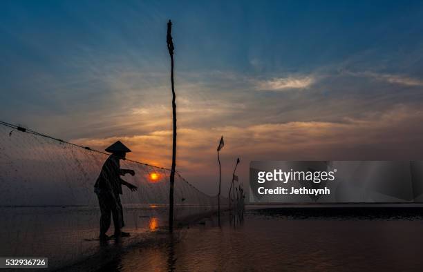 silhouette of fishing net and woman in sunrise at beach - hot vietnamese women stock pictures, royalty-free photos & images