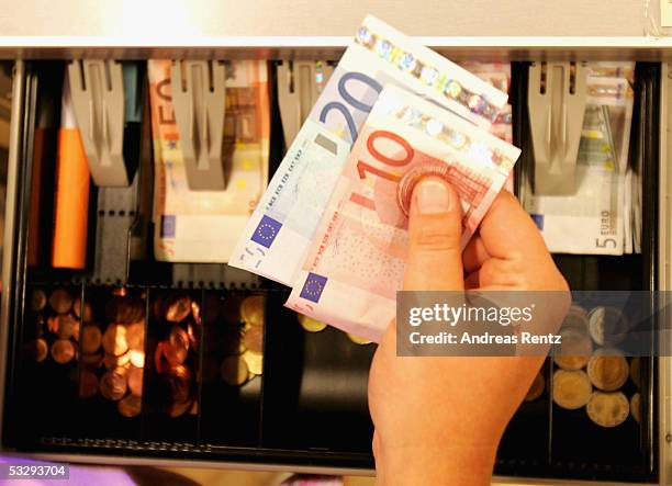 Cashier puts Euro banknotes into a cash register on July 27, 2005 in Luneburg, Germany. Sparked by the election manifesto of the opposition party...