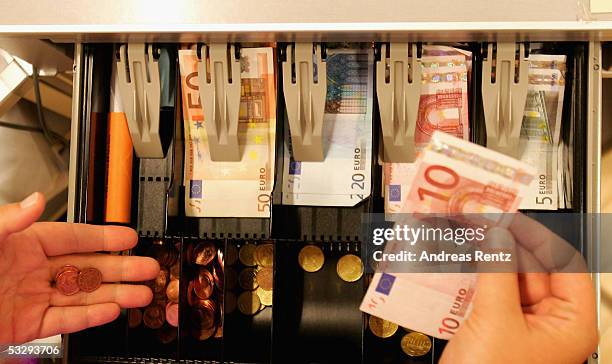 Cashier puts Euro banknotes into a cash register on July 27, 2005 in Luneburg, Germany. Sparked by the election manifesto of the opposition party...