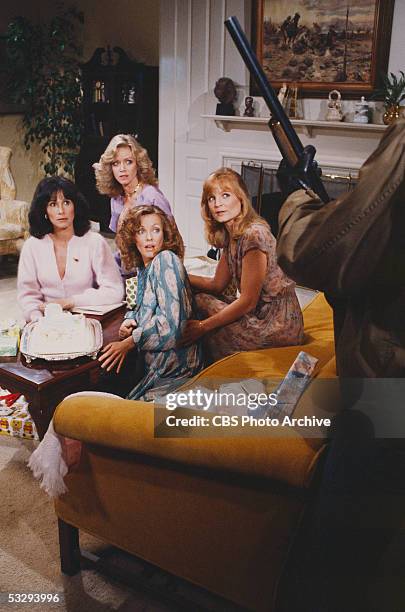 American actresses Michele Lee , Donna Mills , Kim Lankford , and Constance McCashin cower from a partially visible shotgun-wielding person in the...