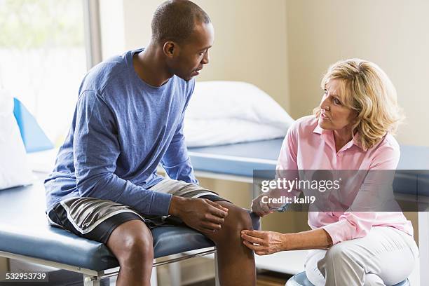 physical therapist examining patient - orthopedie stockfoto's en -beelden