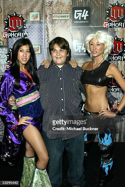 Talk show host Andy Milonakis poses with two video game vixens during the arrivals for the G-phoria Awards at the Los Angeles Center Studios on July...