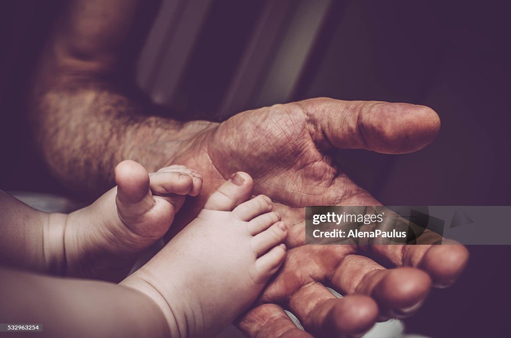 Vater Halten sein kleines Baby Füße