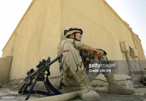 Soldier from 3rd Brigade of 3rd Infantry Division sits against the wall on the roof of a government building of the Diyala province 28 July 2005 in...
