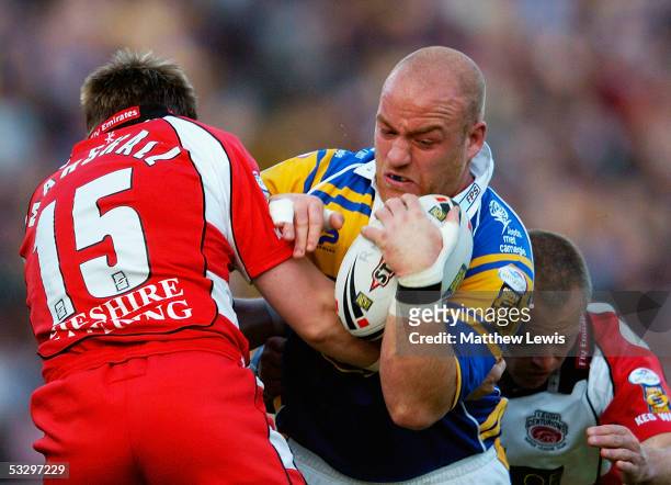 Danny Ward of Leeds is stopped by Leigh's Richard Marshall and Matt Sturm during the Engage Super League match between Leeds Rhinos and Leigh...