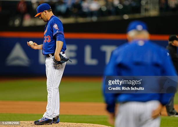 Pitcher Matt Harvey of the New York Mets stares at the ball as manager Terry Collins comes out to relieve him during the third inning against the...