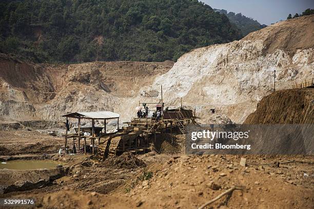 Miners work on a rock washing and separating machine at the Lian Shan open pit ruby mine in Mogok, Mandalay, Myanmar, on Tuesday, March 15, 2016. In...