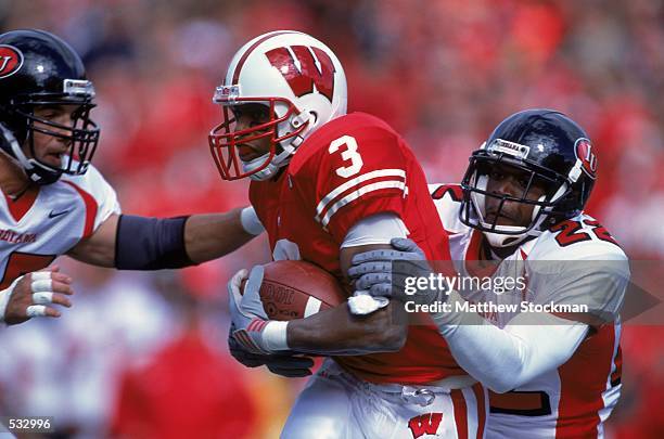 Lee Evans of Wisconsin Badgers gets tackled by Sharrod Wallace of the Indiana Hoosiers during the game at the Camp Randall Stadium in Madison,...