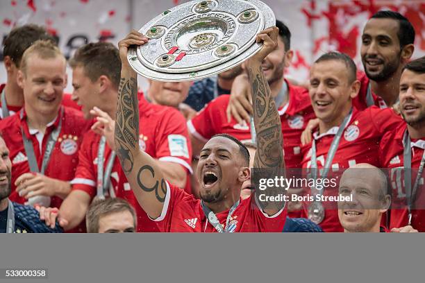 Jerome Boateng of Muenchen lifts the Meisterschale as players and staffs celebrate the Bundesliga championship after the Bundesliga match between FC...