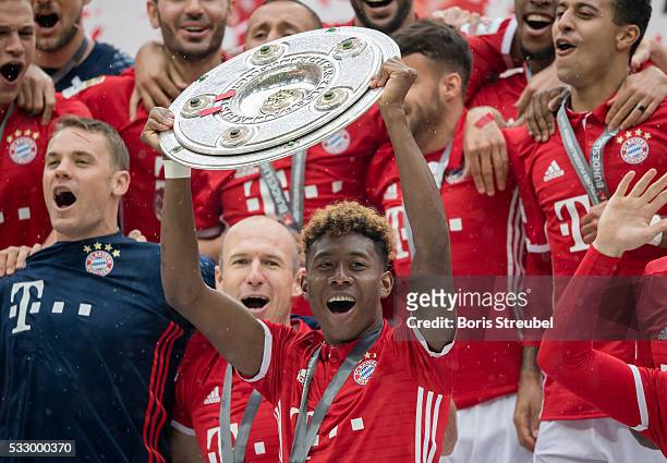 David Alaba of Muenchen lifts the Meisterschale as players and staffs celebrate the Bundesliga championship after the Bundesliga match between FC...