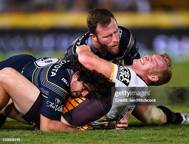 Jack Reed of the Broncos is tackled by Gavin Cooper and Jake Granville of the Cowboys during the round 11 NRL match between the North Queensland...