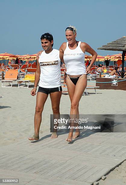 Brigitte Nielsen and her husband Mattia Dessi walk on the beach on July 29, 2005 in Cervia, Italy.