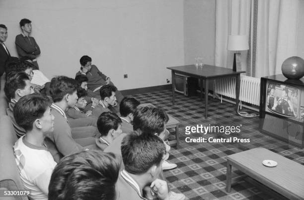 Members of the North Korean World Cup squad watching 'Towed In A Hole', a Laurel & Hardy comedy, on TV in their hotel. The team is in Middlesbrough...
