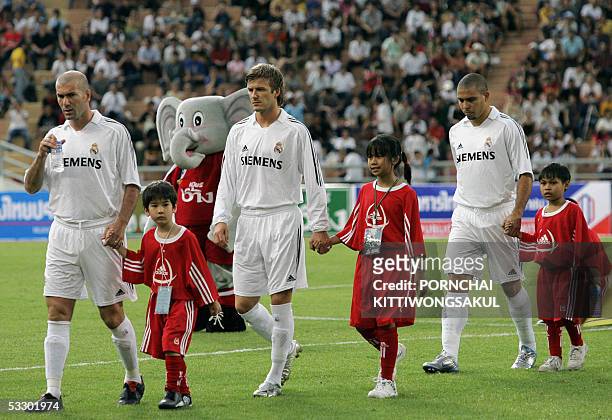 Real Madrid football players, Zinedine Zidane , David Beckham and Ronaldo Luiz,along with Thai host girls, enter the stadium prior to an exhibition...