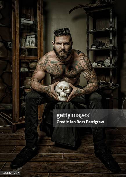 tattooed man holding skull - skull tattoos fotografías e imágenes de stock