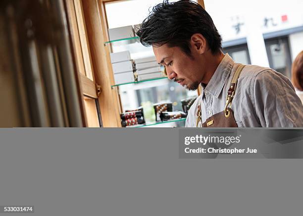 Owner and barista of specialty coffee shop Onibus Coffee Atsushi Sakao prepares drip coffee on May 20, 2016 in Tokyo, Japan. With the rise of...