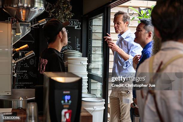 Customers speak with staff at specialty coffee shop Onibus Coffee on May 20, 2016 in Tokyo, Japan. With the rise of specialty coffee shops opening...