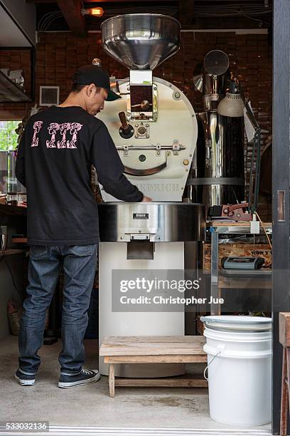 An employee of specialty coffee shop Onibus Coffee inspects roasted coffee beans on May 20, 2016 in Tokyo, Japan. With the rise of specialty coffee...