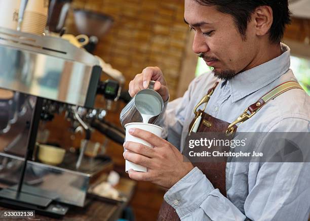 Owner and barista of specialty coffee shop Onibus Coffee Atsushi Sakao prepares a cafe latte on May 20, 2016 in Tokyo, Japan. With the rise of...