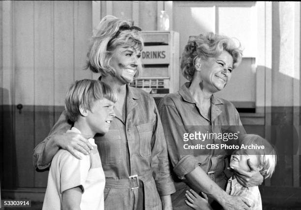 American actresses Doris Day, as Doris Martin, and Rose Marie, as Myrna Gibbons, with their faces dirty from grease and wearing mechanics' jumpsuits,...