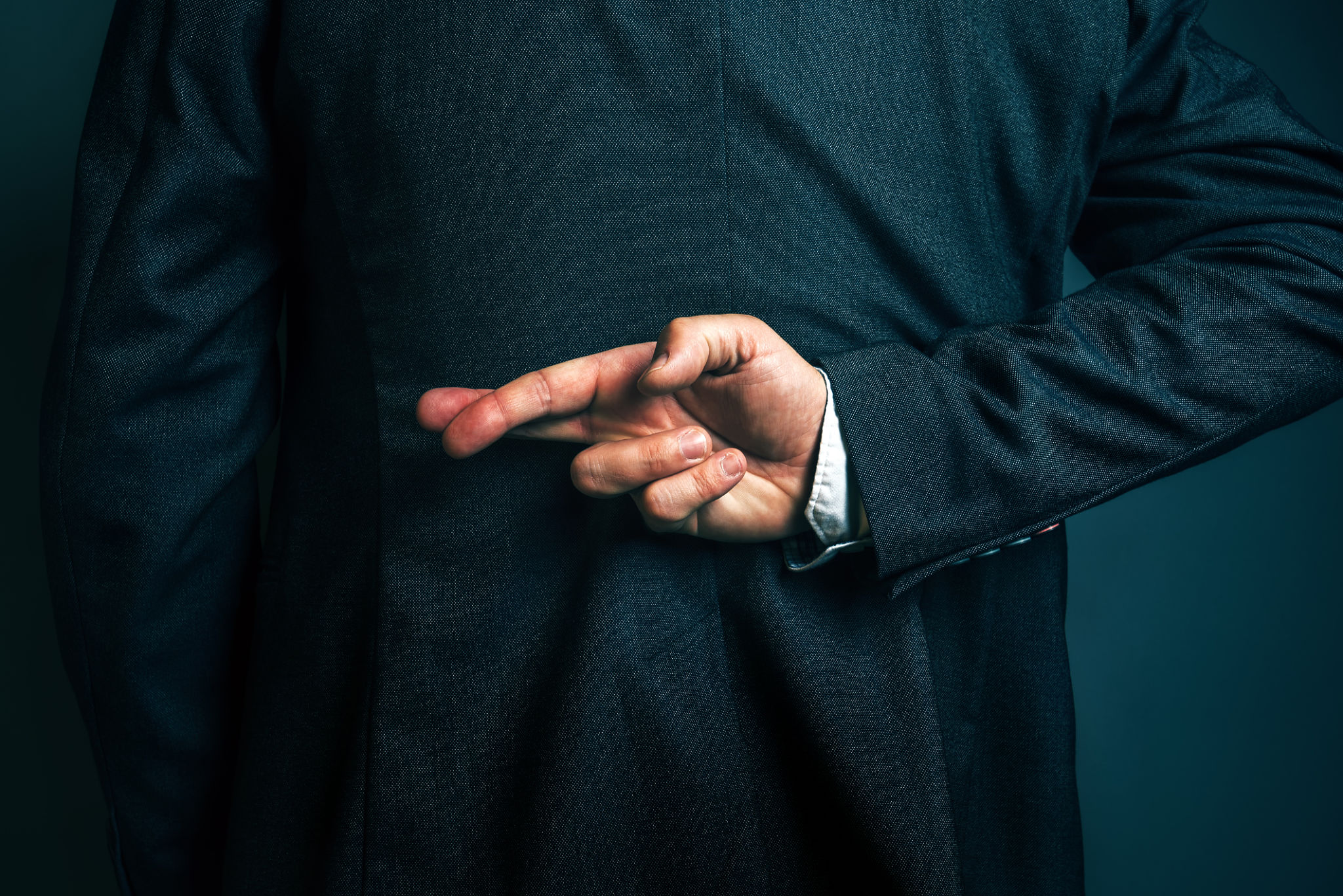 Lying businessman holding fingers crossed behind his back Lying businessman holding fingers crossed behind his back
