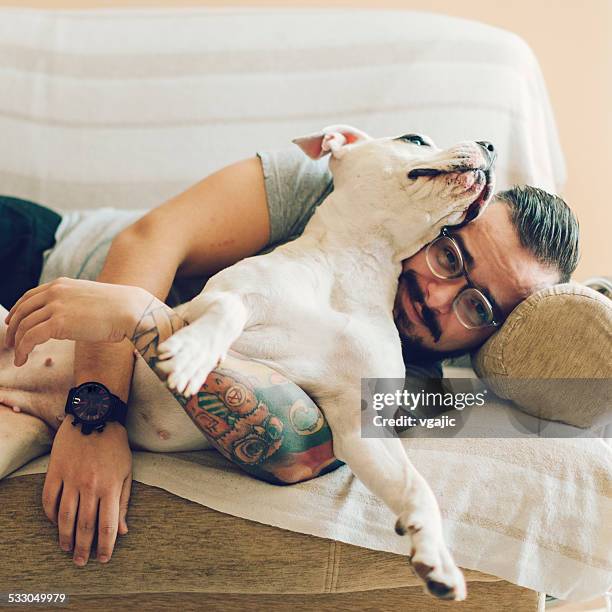 man with tattoo embracing his dog. - man tatoo bildbanksfoton och bilder