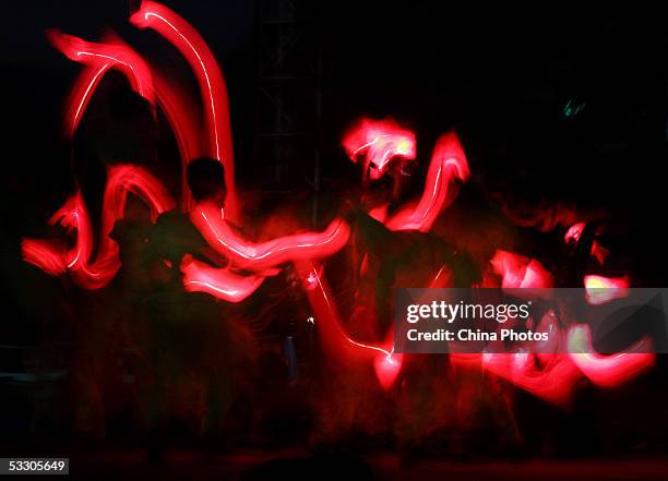 Athletes holding torch shaped stick lights, perform the Torch Dance during the opening ceremony of the Liangshan Yi Ethnic Minority Torch Festival on...