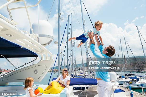 happy young family on motor yacht - marina stock pictures, royalty-free photos & images