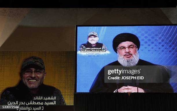 Lebanese Shiite militant group Hezbollah's leader, Hassan Nasrallah is seen on a giant screen broadcasting his speech on May 20, 2016 in a southern...