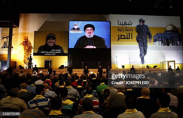 Lebanese Shiite militant group Hezbollah's leader, Hassan Nasrallah is seen on a giant screen broadcasting his speech on May 20, 2016 in a southern...
